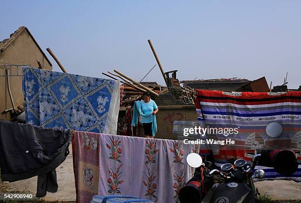 June 25: A villager drying clothes in Danping Village of Chenliang Township in Funing, Yancheng, east China's Jiangsu Province, June 25, 2016. A...