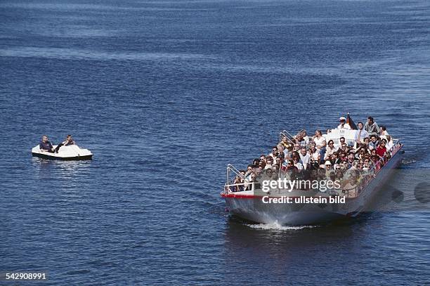 Alster-Cabrio der ATG Alster-Touristik GmbH, vollbesetzt mit Fahrgästen während einer Rundfahrt über die Aussenalster. Daneben ein Tretboot....