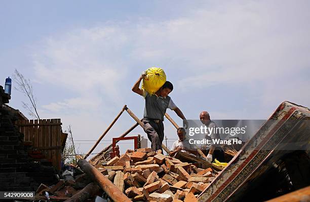 June 25: Villagers move food from collapsed houses in Danping Village of Chenliang Township in Funing, Yancheng, east China's Jiangsu Province, June...