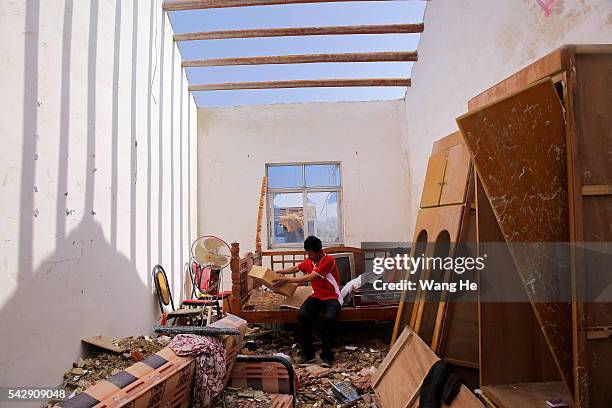 June 25: Villager are seen at him collapsed house in Danping Village of Chenliang Township in Funing, Yancheng, east China's Jiangsu Province