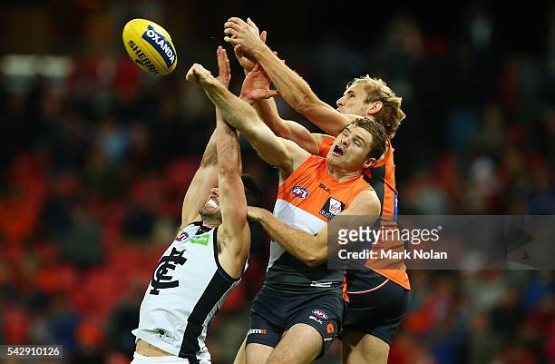 Andrew Walker of Carlton, Heath Shaw and Nic Hayes of the Giants contest a mark during the round 14 AFL match between the Greater Western Sydney...
