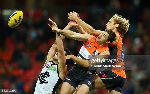Andrew Walker of Carlton, Heath Shaw and Nic Hayes of the Giants contest a mark during the round 14 AFL match between the Greater Western Sydney...