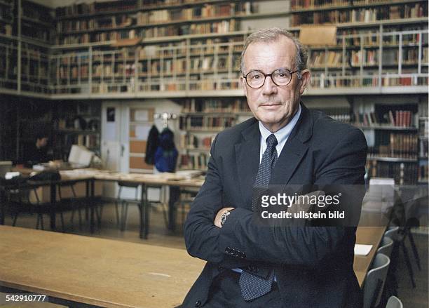 Der Philosoph Prof. Lutger Honnefelder lehnt an einem Lesetisch in der Bibliothek der Universität Bonn, die Arme vor der Brust verschränkt. Im...