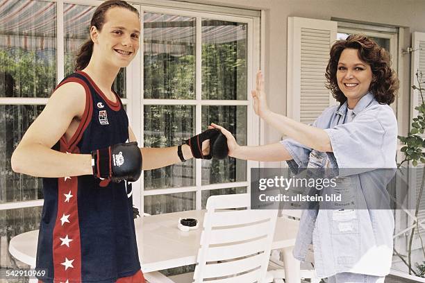 Die Moderatorin Ramona Leiß und ihr Sohn Sascha . Sie stehen auf der Terrasse eines Hauses. Sohn Sascha trägt Sportkleidung und Boxhandschuhe. Er...