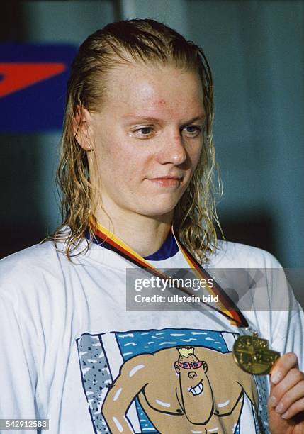 Die Schwimmerin Dagmar Hase, Deutsche Meisterin 100 m Freistil 1996, zeigt ihre Medaille. Aufgenommen Juli 1996.