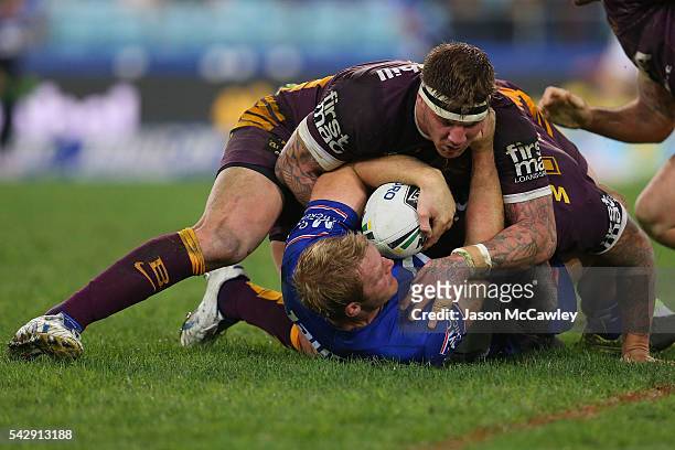 Aiden Tolman of the Bulldogs is tackled by Josh McGuire of the Broncos during the round 16 NRL match between the Canterbury Bulldogs and Brisbane...