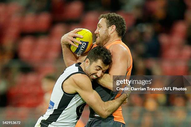 Kade Simpson of the Blues tackles Shane Mumford of the Giants during the round 14 AFL match between the Greater Western Sydney Giants and the Carlton...