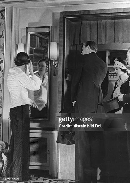 Mss van de Loo and Mr. Von Hagemeister at the wardrobe. Getting ready to go out Picture by Karl Schenker, 1934