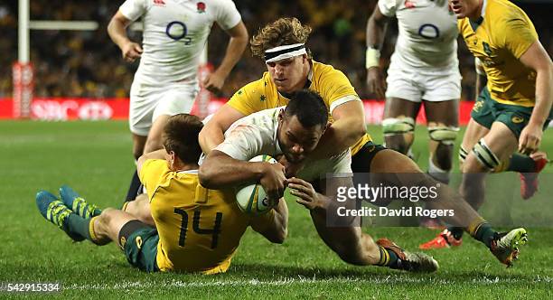 Billy Vunipola of England holds off Dane Haylett-Petty and Michael Hooper to score their third try during the International Test match between the...