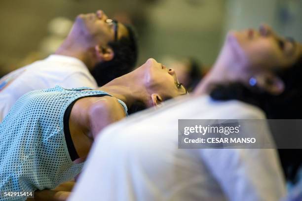 Participants practice yoga during the Stomp Yoga Masterclass part of the 17th edition of IIFA Awards in Madrid on June 24, 2016. - The IIFA Awards...