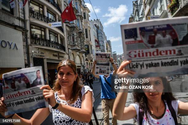 Demonstrators hold copies of pro-Kurdish newspaper "Ozgur Gundem" as they a protest against the arrest of three prominent activists for press freedom...