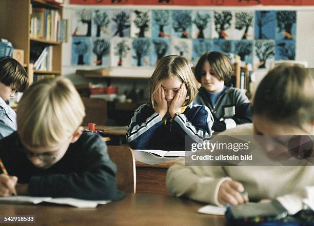 Eine Schülerin sitzt erschöpft im Klassenzimmer. Grundschule; Lernprobleme; Konzentrationsschwierigkeit; Schüler. Symbolbild .