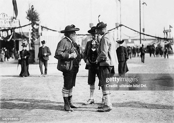 Germany, Bavaria, Munich. Oktoberfest. Three Bavarians wearing Lederhosen and traditional jackets and hats - around 1910 - Picture by Filip Kester