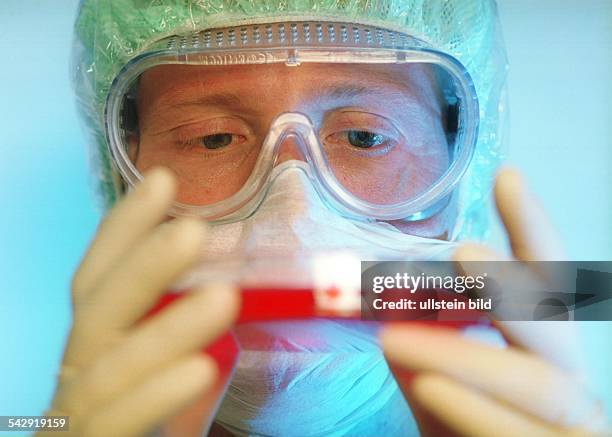 Wissenschaftler mit einer Petrischale mit Bakterienkulturen. Biotechnologie; Pharmazie; Biologie; Forscher; Forschung; Schutzbrille. Symbolbild .