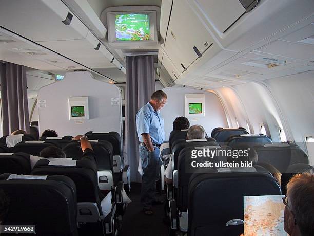 Economy Class mit Passagieren in einer Chartermaschine der LTU vom Typ Boeing 767. Bildschirm; Bordfernsehen; Fernsehen; Fluggast; Flugpassagier;...