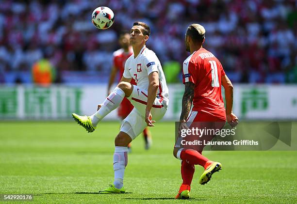 Arkadiusz Milik of Poland controls the ball under pressure of Valon Behrami of Switzerland during the UEFA EURO 2016 round of 16 match between...