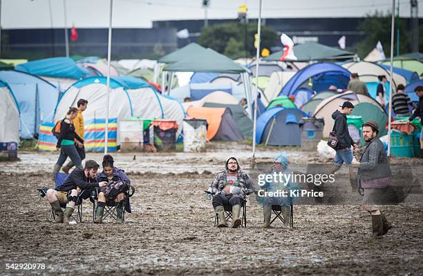 People sit on chairs in the mud while SHURA performs on The Other stage on Day 2 of the Glastonbury Festival 2016 at Worthy Farm, Pilton on Saturday,...