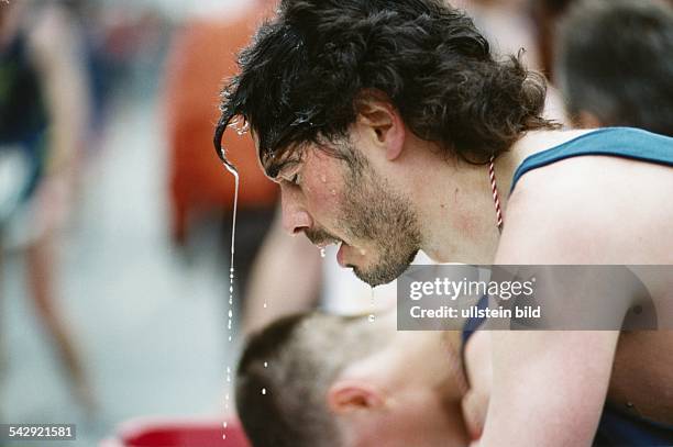 Ein Läufer erfrischt sich nach dem Hamburger hanse-Marathon 1997. Die Augen vor Erschöpfung geschlossen rinnt ihm Wasser aus seinem Haar, läuft über...