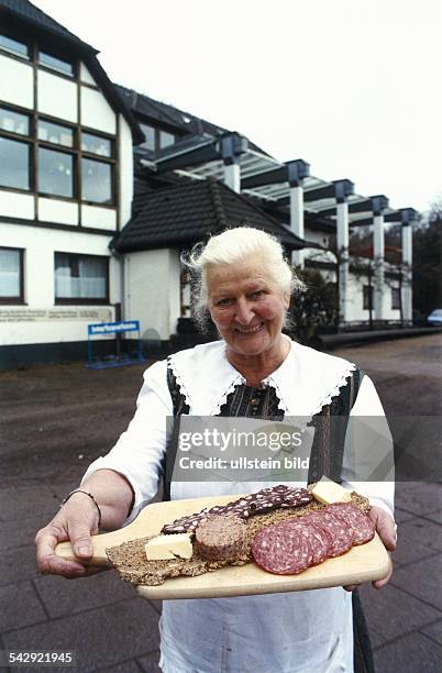 Irma Schuster, Wirtin im Gasthaus "Zum Kiekeberg" in Ehestorf, zeigt eine Schlachtplatte mit frischer Mettwurst, Blut- und Leberwurst auf...