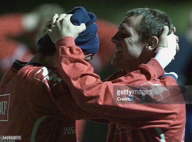 Les arrières du XV de France de rugby David Bory et Clément Poitrenaud étirent leurs nuques, le 12 novembre 2001 lors d'une séance d'entraînement à...