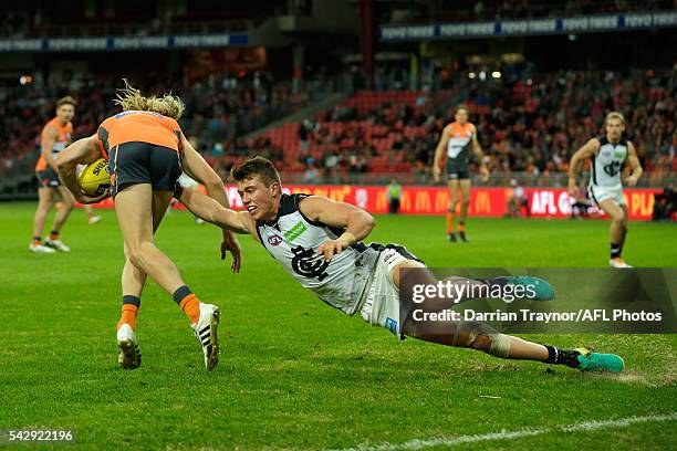 Patrick Cripps of the Blues dives in an attempt to tackle Nick Haynes of the Giants during the round 14 AFL match between the Greater Western Sydney...