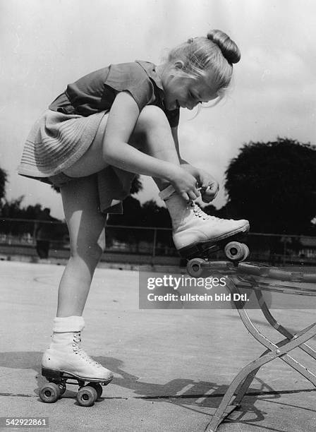 Mädchen vom Berliner Rollschuhclub schnürt sich die Rollschuhe zu- 1952