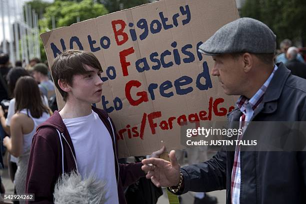 Demonstrator holds a placard as he remonstrates with a pedestrian during a protest against the pro-Brexit outcome of the UK's June 23 referendum on...