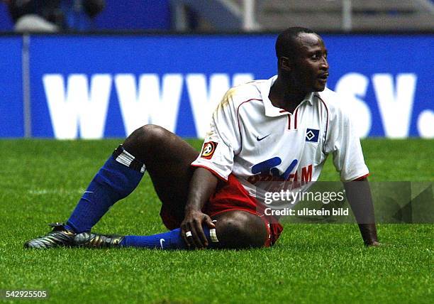 Der ghanaische Stürmer Anthony Yeboah vom Fußball-Bundesligisten Hamburger SV sitzt auf dem Rasen. .