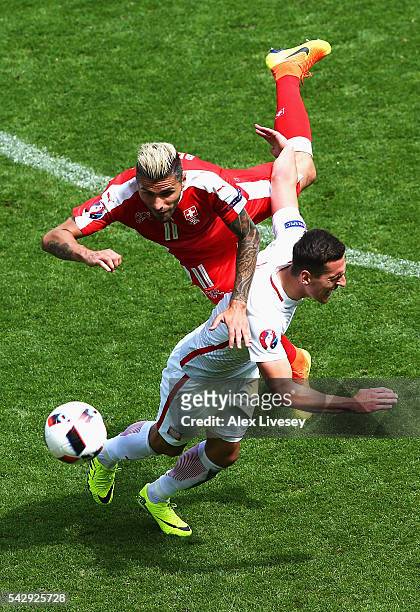 Arkadiusz Milik of Poland and Valon Behrami of Switzerland compete for the ball during the UEFA EURO 2016 round of 16 match between Switzerland and...