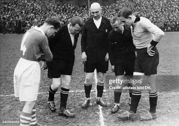 Fussballspiel, Schiedsrichter, Linienrichter und Spieler nach dem Werfen der Muenze zur Seitenwahl- 1951