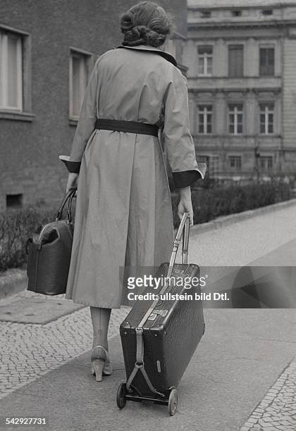 Frau mit Reisegepäck, der Koffer wird mit einem Koffer-Kuli transportiert - 1954