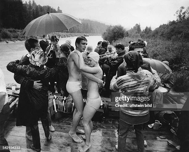 Jugendliche tanzen im Regen mit Musik auf einem Riverboat, in der Mitte ein Paar mit Badebekleidung- 1968