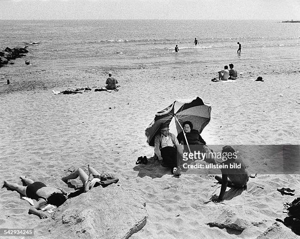 Menschen am Strand in Südfrankreich, ein älteres Paar sitzt unter einem Sonnenschirm - 1971