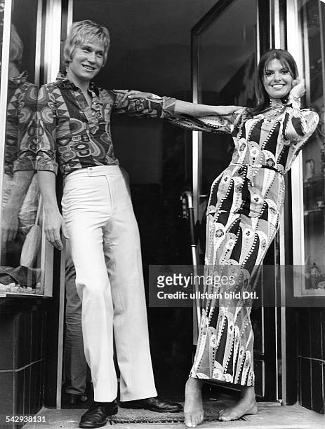 Zwei Models posieren vor der Jet-Boutique am Kurfürstendamm BerlinEr trägt ein gemustertes Oberhemd und eine weisse Hose, sie trägt ein gemustertes...