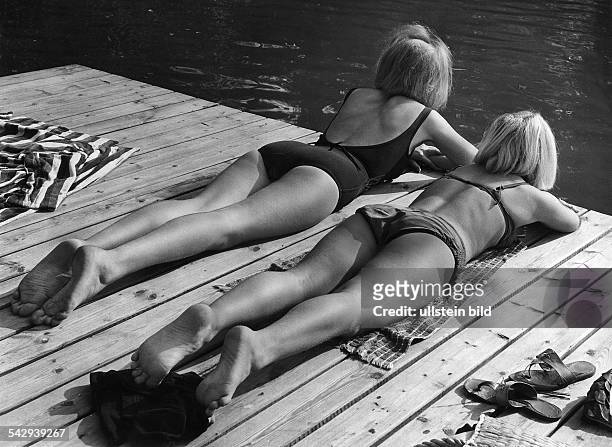 Zwei Mädchen liegen auf einem Holzsteg in der Sonne1965