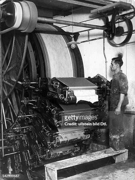 Herstellung von Tapeten. Arbeiter an einer Druckmaschine für Tapeten- 1935
