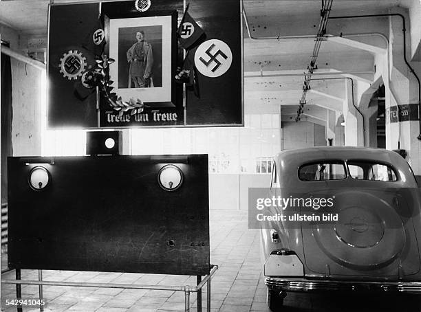 Adam Opel A.G. , Fabrik Rüsselsheim im III. Reich: Blick in eine Werkshalle mit einer grossen Ehrentafel, die ein Bild von Adolf Hitler zeigt,...