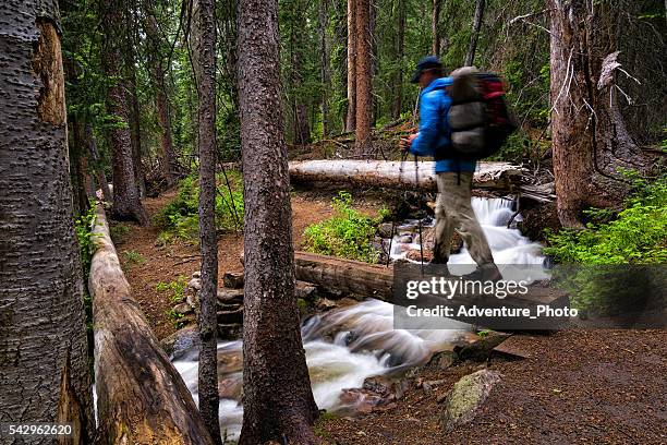 hiker crosses bridge over mountain creek - vail colorado stock pictures, royalty-free photos & images