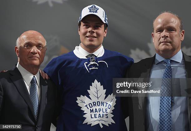 Auston Matthews poses onstage with general manager Lou Lamoriello, left, and director of player personnel Mark Hunter of the Toronto Maple Leafs...