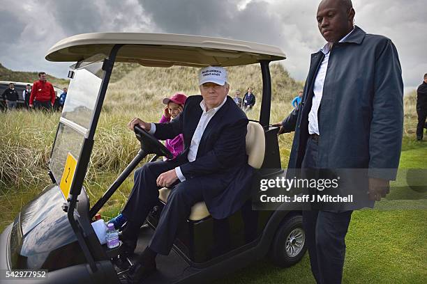 Presumptive Republican nominee for US president Donald Trump, and his granddaughter Kai visit Trump International Golf Links on June 25, 2016 in...