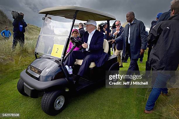 Presumptive Republican nominee for US president Donald Trump and his granddaughter Kai visit Trump International Golf Links on June 25, 2016 in...