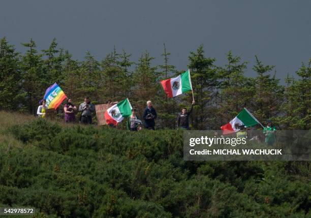Group of protesters wave Mexican flags on the hillside above the Trump International Golf Links minutes before presumptive Republican presidential...