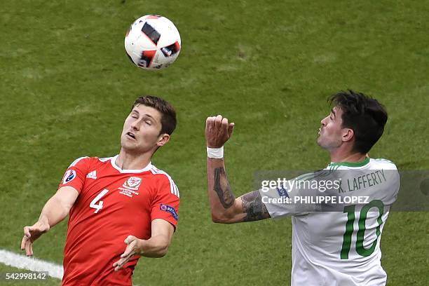 Northern Ireland's forward Kyle Lafferty in action against Wales' defender Ben Davies during the Euro 2016 round of sixteen football match Wales vs...