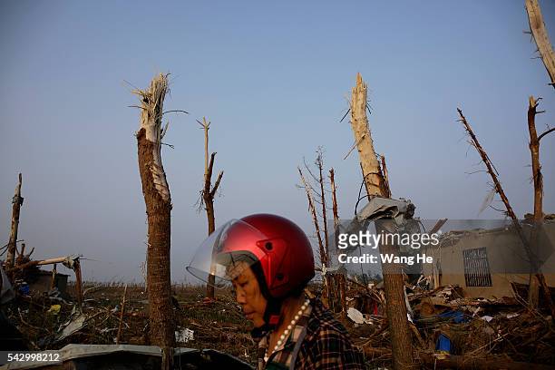Villager passes through debris in Beichen Village of Chenliang Township in Funing, Yancheng, east China's Jiangsu Province on June 25, 2016. A total...