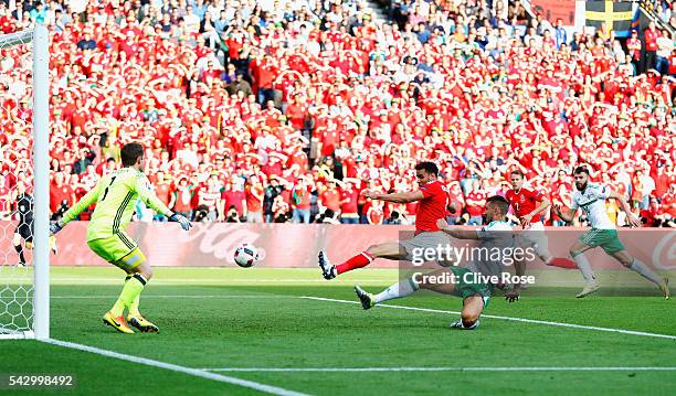 Gareth McAuley of Northern Ireland scores an own goal past Michael McGovern during the UEFA EURO 2016 round of 16 match between Wales and Northern...