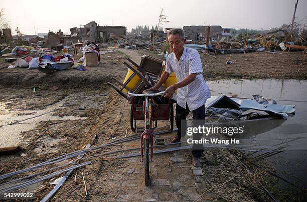 Villager carry away the property of the damaged house in Beichen Village of Chenliang Township in Funing, Yancheng, east China's Jiangsu Province on...