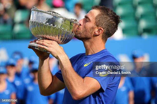 Steve Johnson of the United States holds his trophy aloft as he kisses after defeating Pablo Cuevas of Uruguay in his men's singles final match...