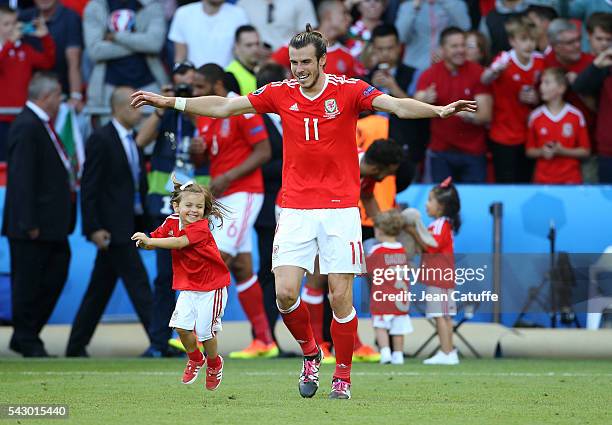 Gareth Bale of Wales celebrates the victory with his daughter Alba Bale on the pitch following the UEFA EURO 2016 round of 16 match between Wales and...