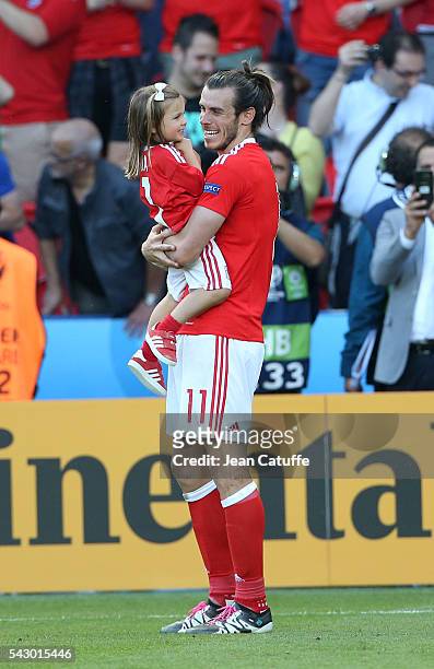Gareth Bale of Wales celebrates the victory with his daughter Alba Bale on the pitch following the UEFA EURO 2016 round of 16 match between Wales and...