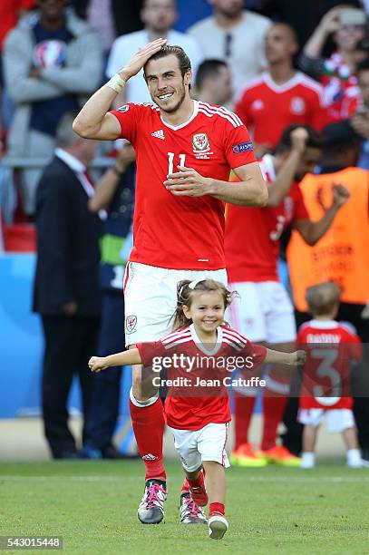 Gareth Bale of Wales celebrates the victory with his daughter Alba Bale on the pitch following the UEFA EURO 2016 round of 16 match between Wales and...